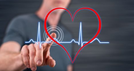 Man touching a heart beats graph on a touch screen with his finger